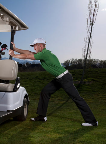 golfer stretching on golf cart