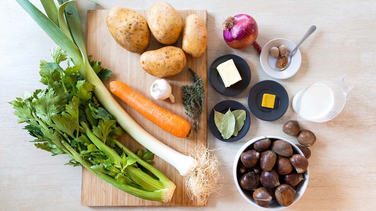 ingredients for chestnut soup, including chestnuts, celery, leek, carrot and potatoes