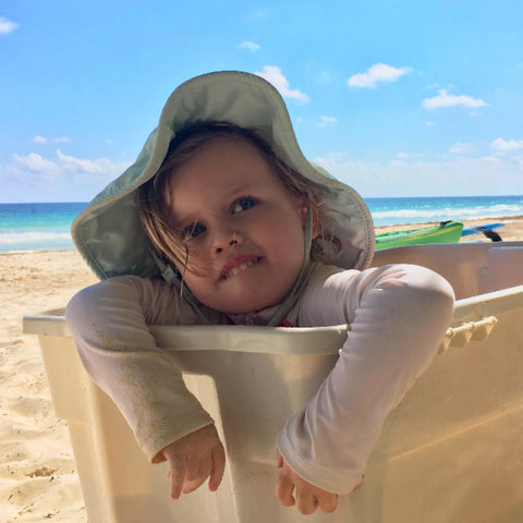 Gucci's daughter Petal sits in a basket on the beach