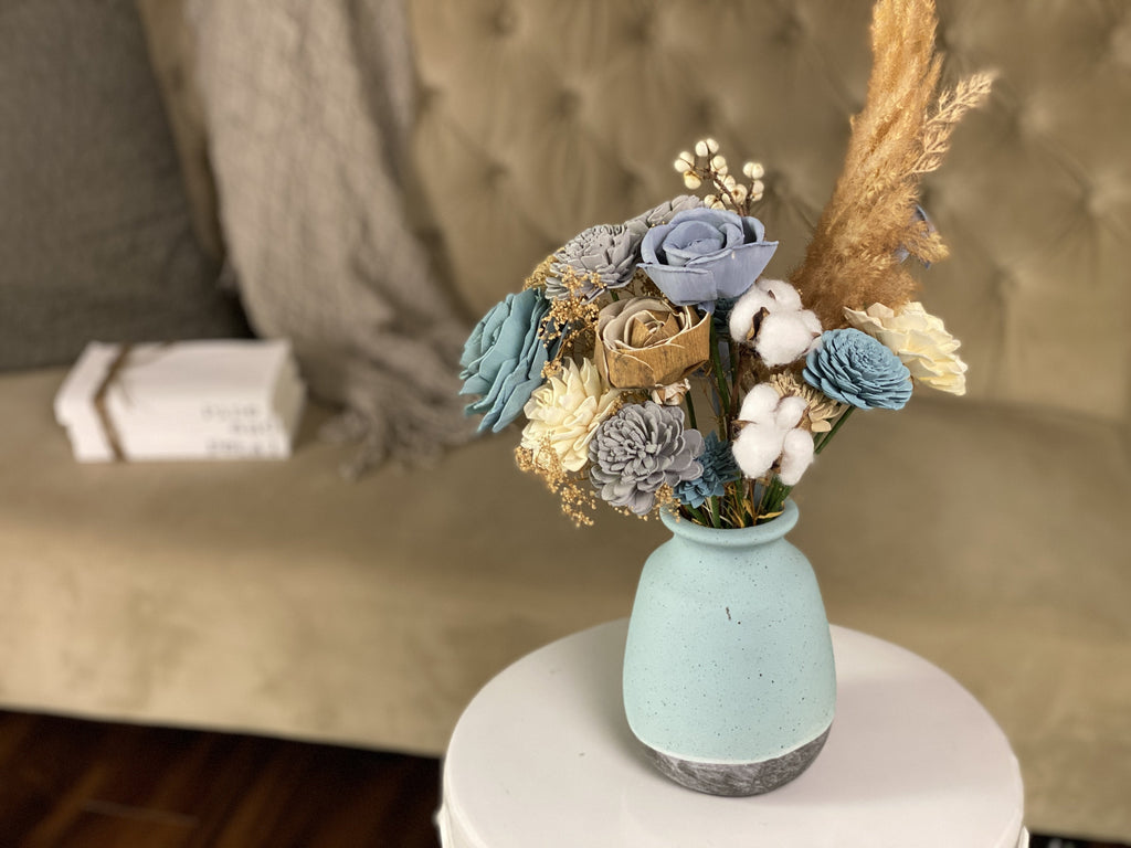 sola wood flower arrangement in blue vase by pine and petal market