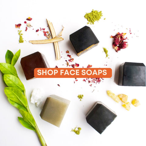 Five face soap bars with powdered ingredients scattered around