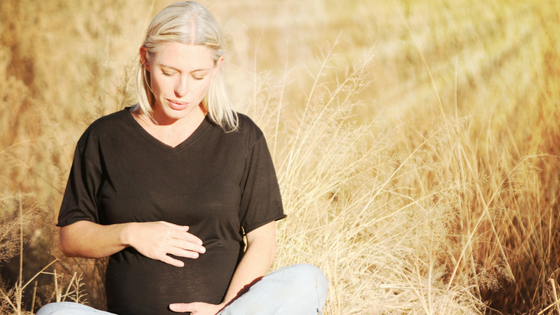 Pregnant woman in grass field