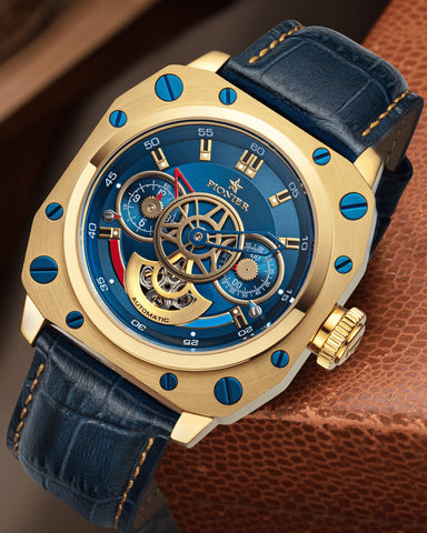 Newport automatic Pionier watch with blue dial, gold case, and blue leather band.