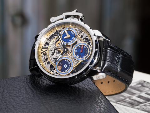 Oman is a mechanical watch for men from Tufina. This silver watch for man has a real black leather band. It is a skeleton watch with three blue sub dials and stick double colored hands paired with Roman numerals.