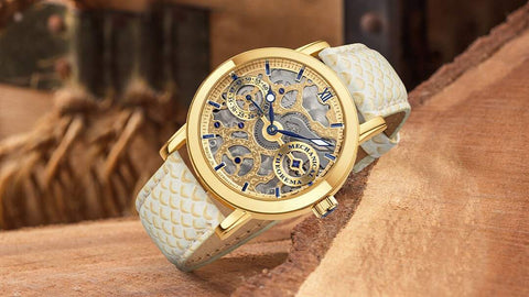 This it Tufina's Melbourne GM-124-3 watch from the Theorema collection, a gold stainless steel case watch with a genuine leather band in a fish skin pattern, mechanical movement and skeletonized dial.