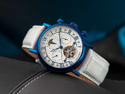Tufina Pionier Basel Tourbillon GM-903-1, a German tourbillon watch for men with a white dial, blue case, white leather band, open heart window, sun & moon phase compilation, Roman numerals and thin blue hands