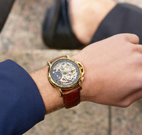 This is Sao Paulo, a skeleton watch for men from Tufina. It has a gold stainless steel case and a real leather band in brown. It comes with a sun and moon phase indicator and double colored hands.