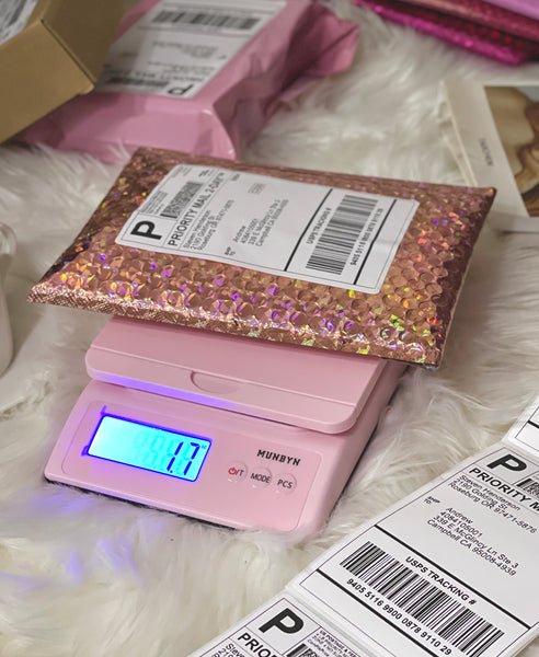 Weighing small parcels with the MUNBYN pink postal scale.
