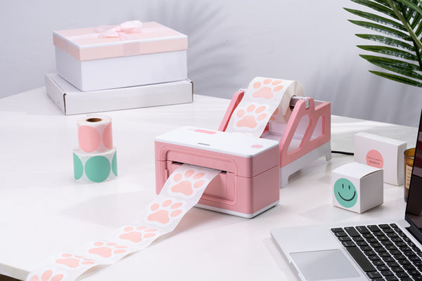 MUNBYN pink shipping label printer is printing pet paw stickers.
