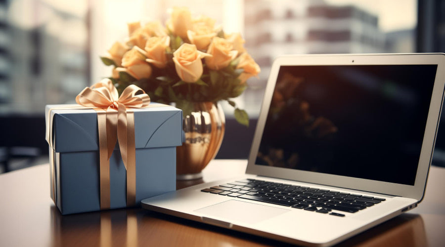 laptop, flowers and gift box on the table