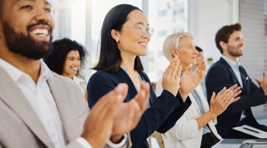 A group of professionals are applauding at an indoor event