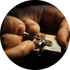Hands crafting detailed metal jewelry