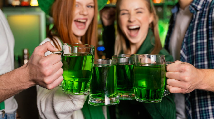 Friends toasting with green drinks