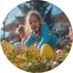 A child crouching on a grassy field with Easter eggs