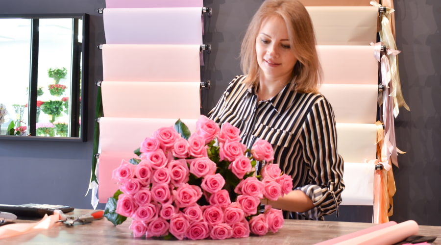 florist makes a bouquet of pink roses