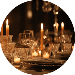 Dimly lit table with candles and glassware for a warm ambiance