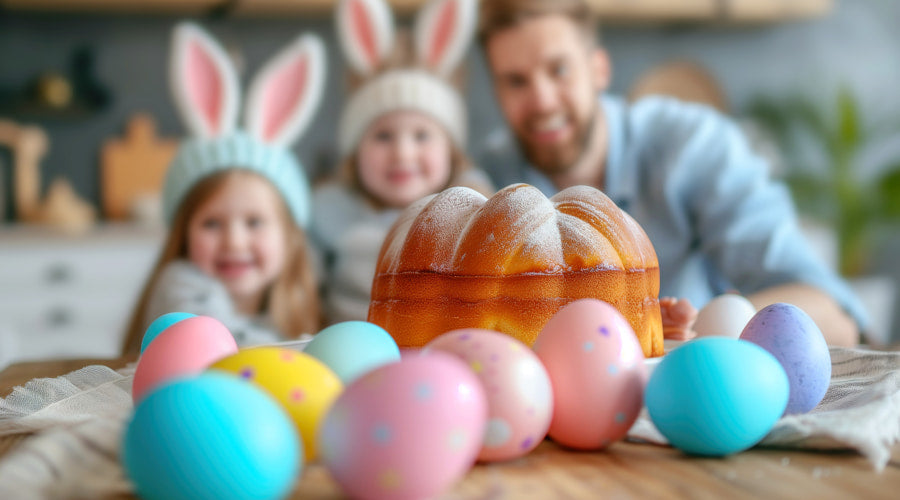 A family wearing bunny ears around a table with a loaf of bread and eggs