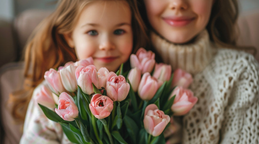 Girl with mother holding tulips, smiling