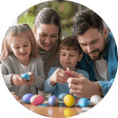 A family of four painting Easter eggs together at a table