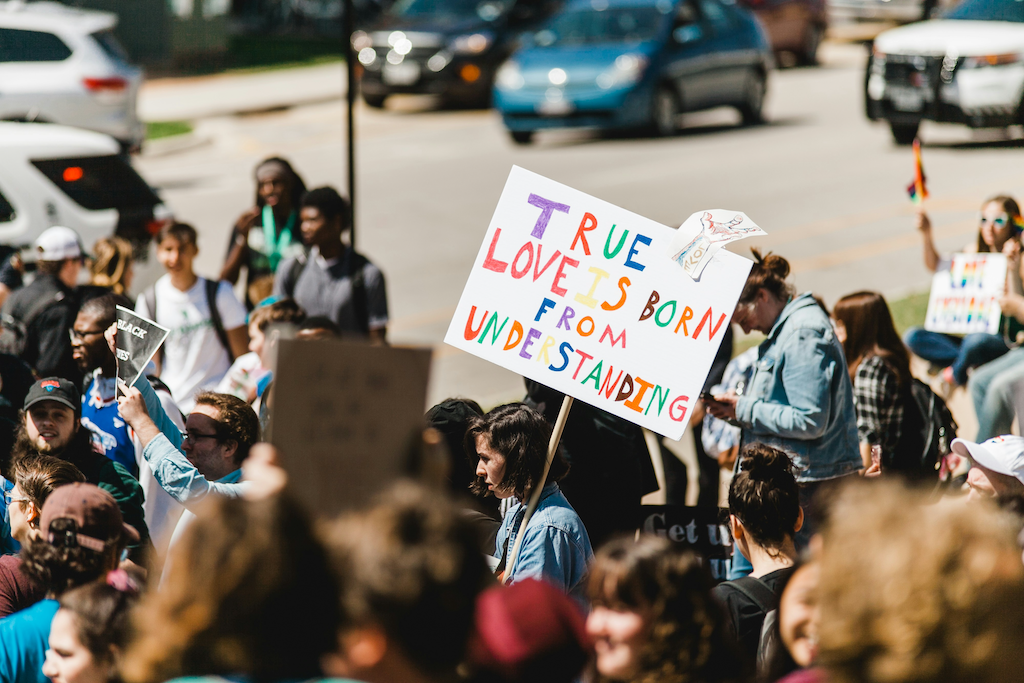 Frau auf einer Demo mit Plakat "Aus Verständnis wird Liebe"