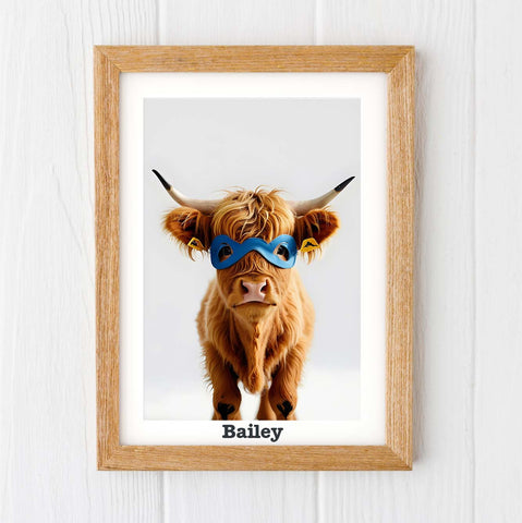 baby highland cow print, framed print of a young highland cow in a superhero mask on a white wall