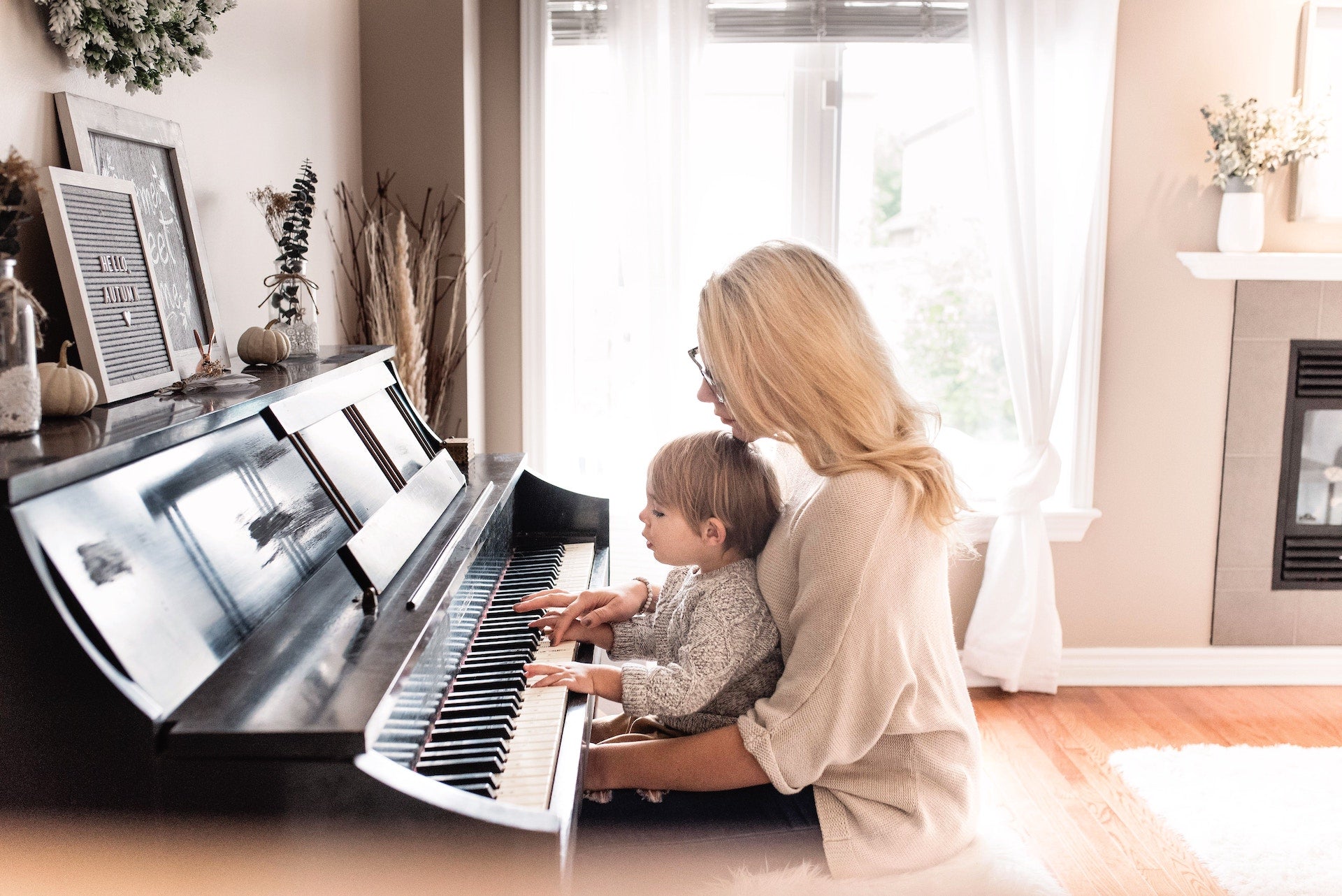 Kid playing Piano with his Mom