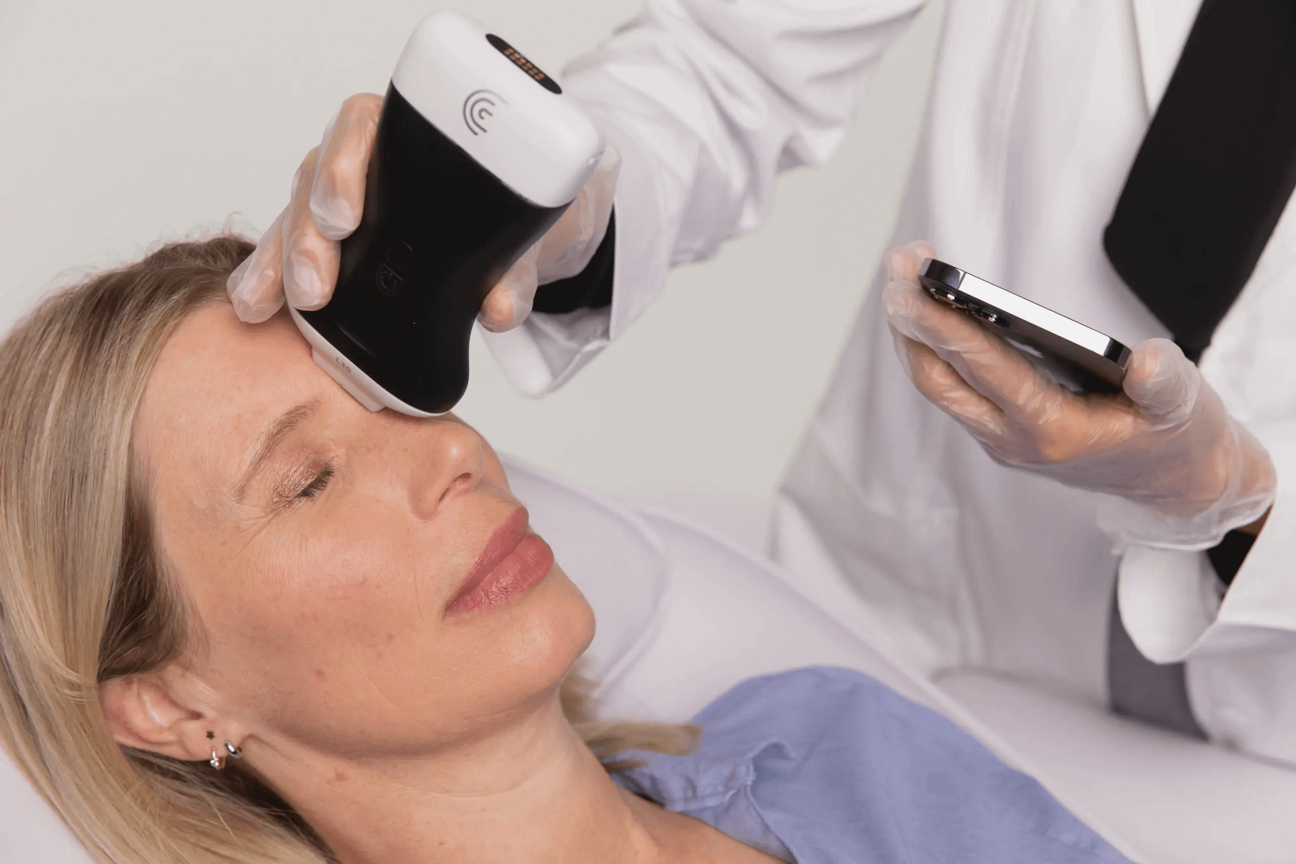 Ultrasound being used on a client's face to determine location of filler