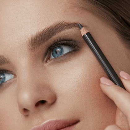 Woman receiving a brow tint service, with henna dye being spread over her eyebrow