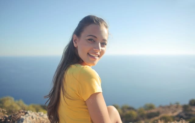 young woman smiling in front of an ocean view