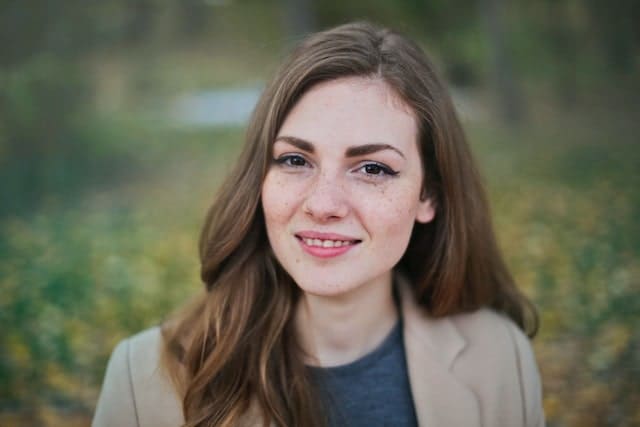 young woman smiling in front of an ocean view