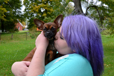 Woman kissing puppy