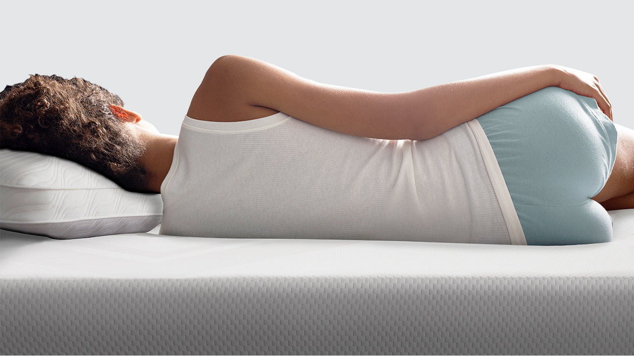 A person lying comfortably on their Temper-pedic mattress