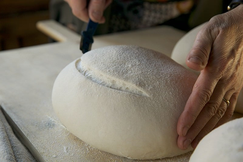 Score dough for bread baked in the Fontana wood-burning oven