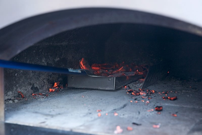 Take coals out of the oven Score dough for bread baked in the Fontana wood-burning oven