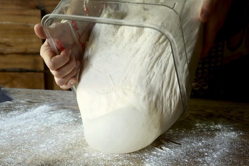 Once doubled in size, transfer the dough on a clean, flour dusted work surface