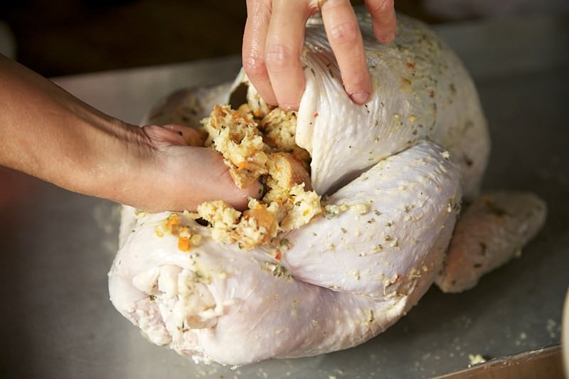 Next place some more stuffing on the neck side of the turkey.