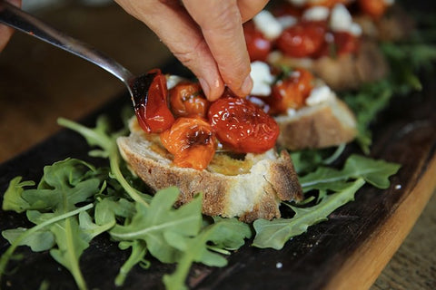 Feta cheese on cherry tomatoes roasted in Fontana wood-fired oven