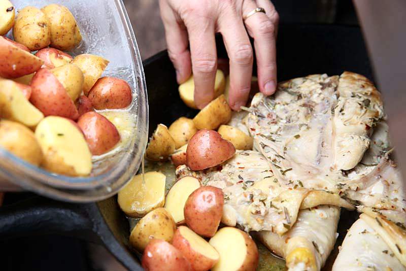 Place potatoes around chicken