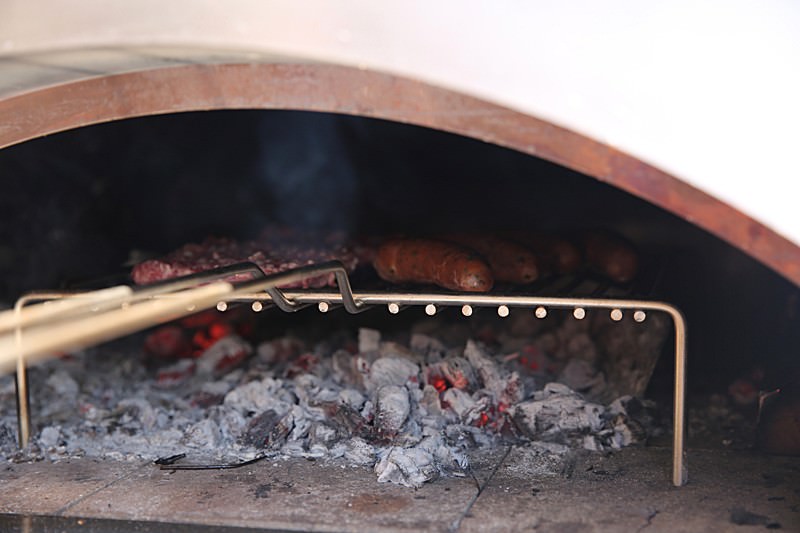 Delicious sausages were placed over hot coals safely laid on top of a very sturdy stainless grill