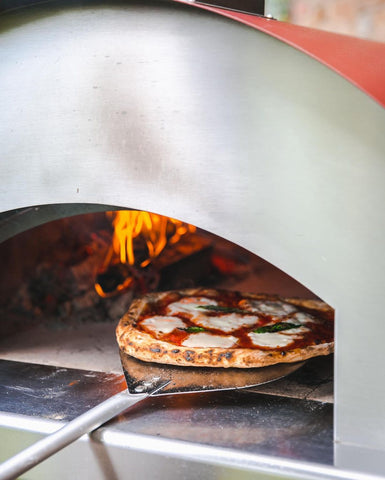 Cooking italian pizza in wood-burning oven