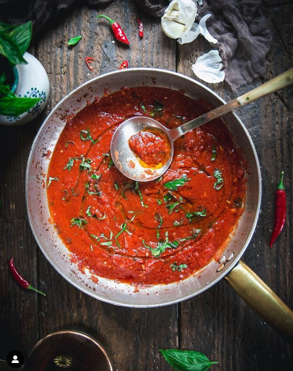pizza sauce in the pan on a wooden background