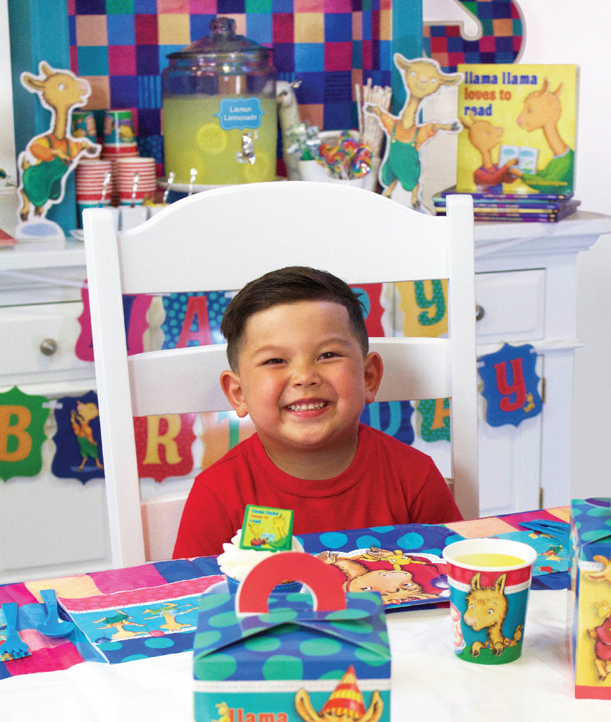 Smiling boy sitting at Llama Llama party table