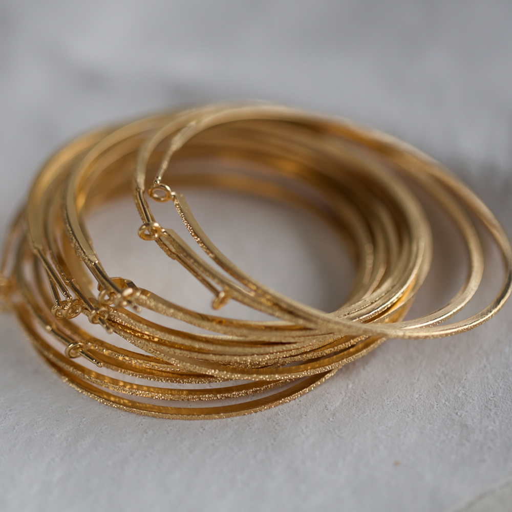 pile of large gold diamond dusted hoops