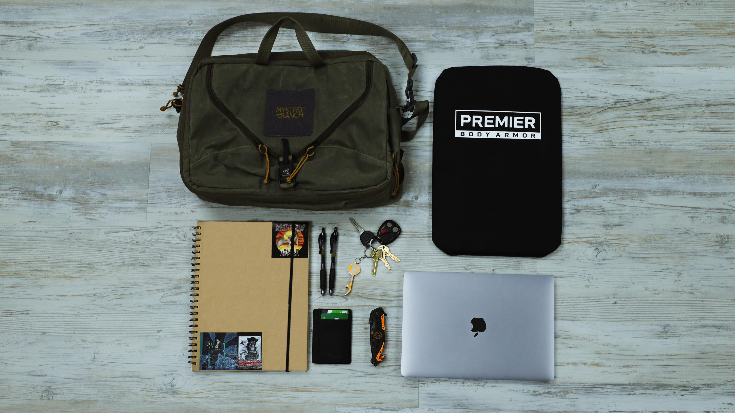 backpack, bulletproof panel, notebook, and computer with keys and wallet
