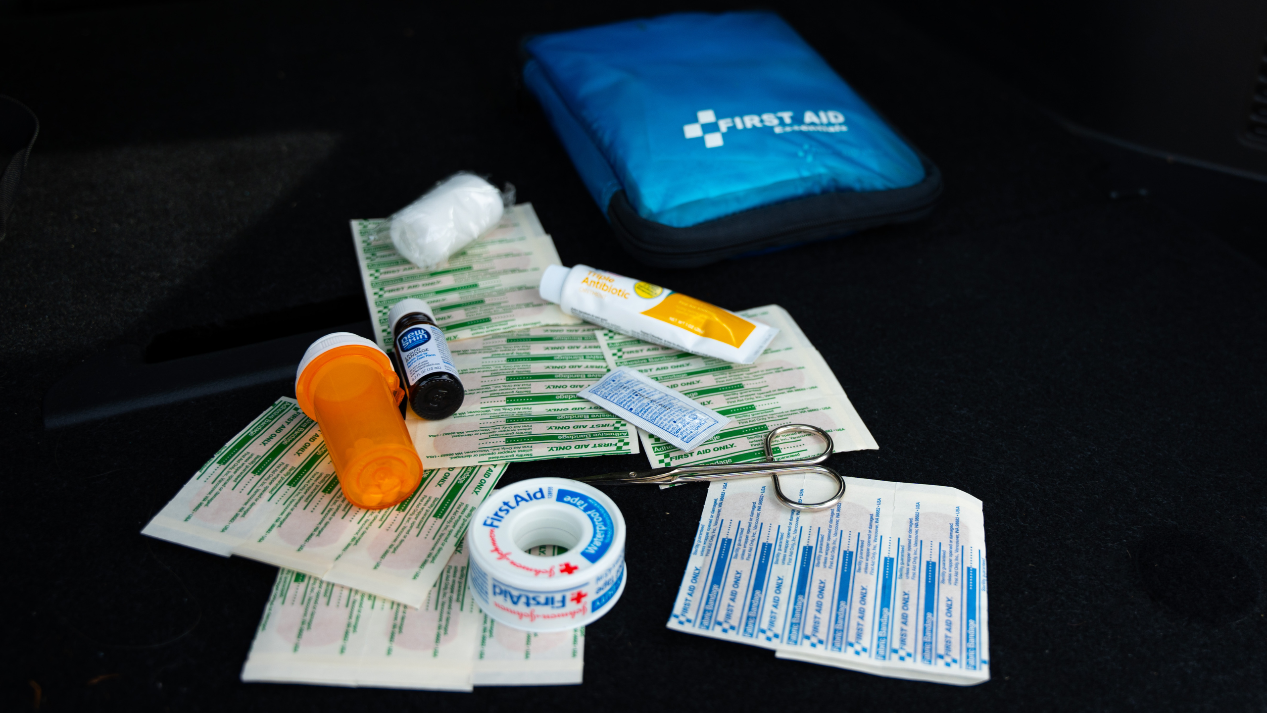 first aid kit items. medicine, band-aids, scissors, gauze.