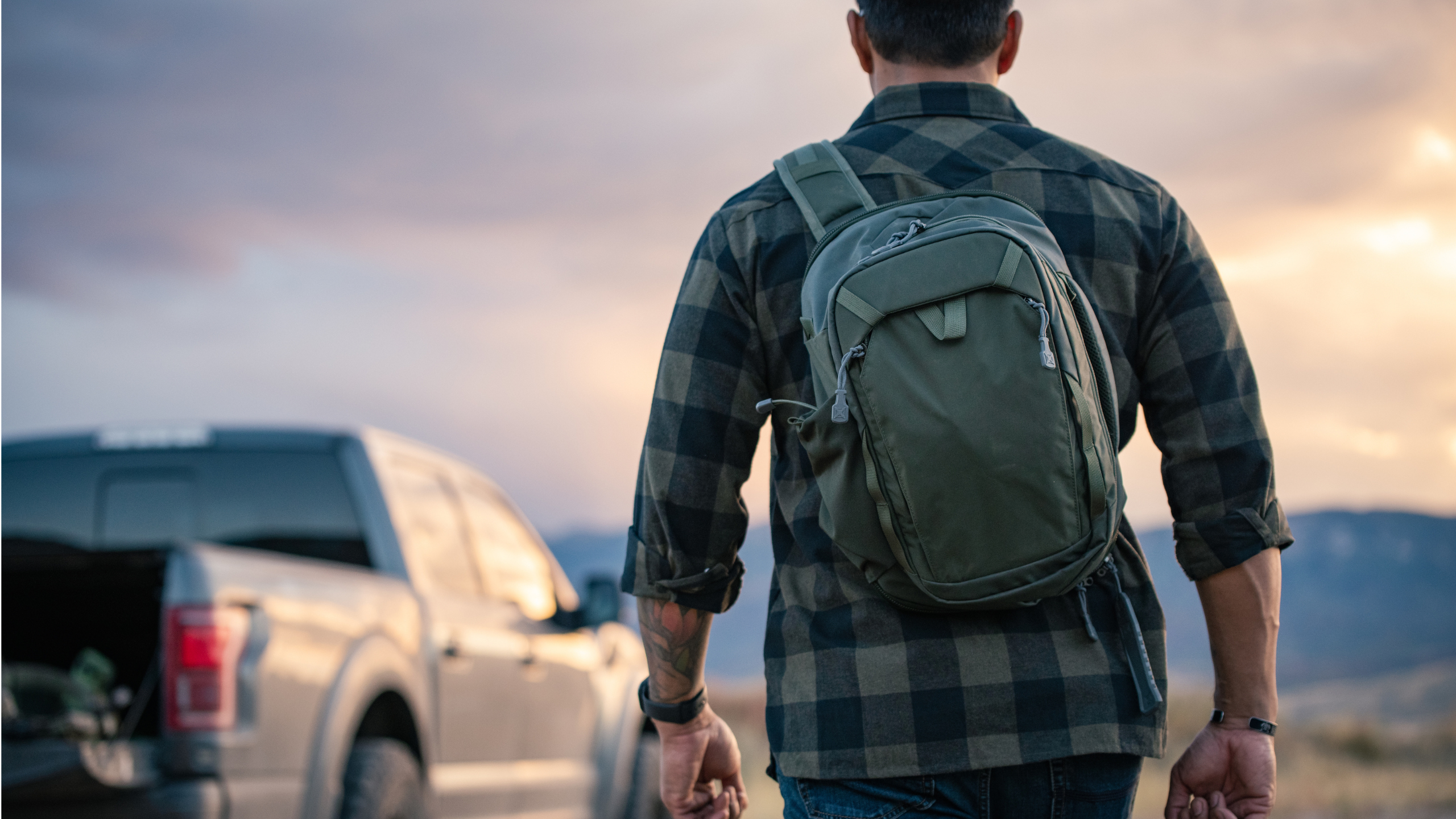 man wearing vertx transit sling backpack outside