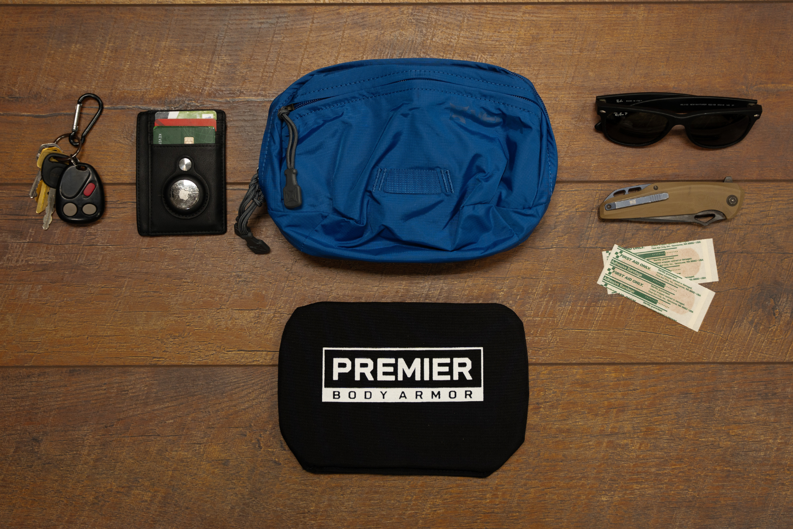 vertx waist pack with bulletproof panel, edc knife, wallet, and medical supplies