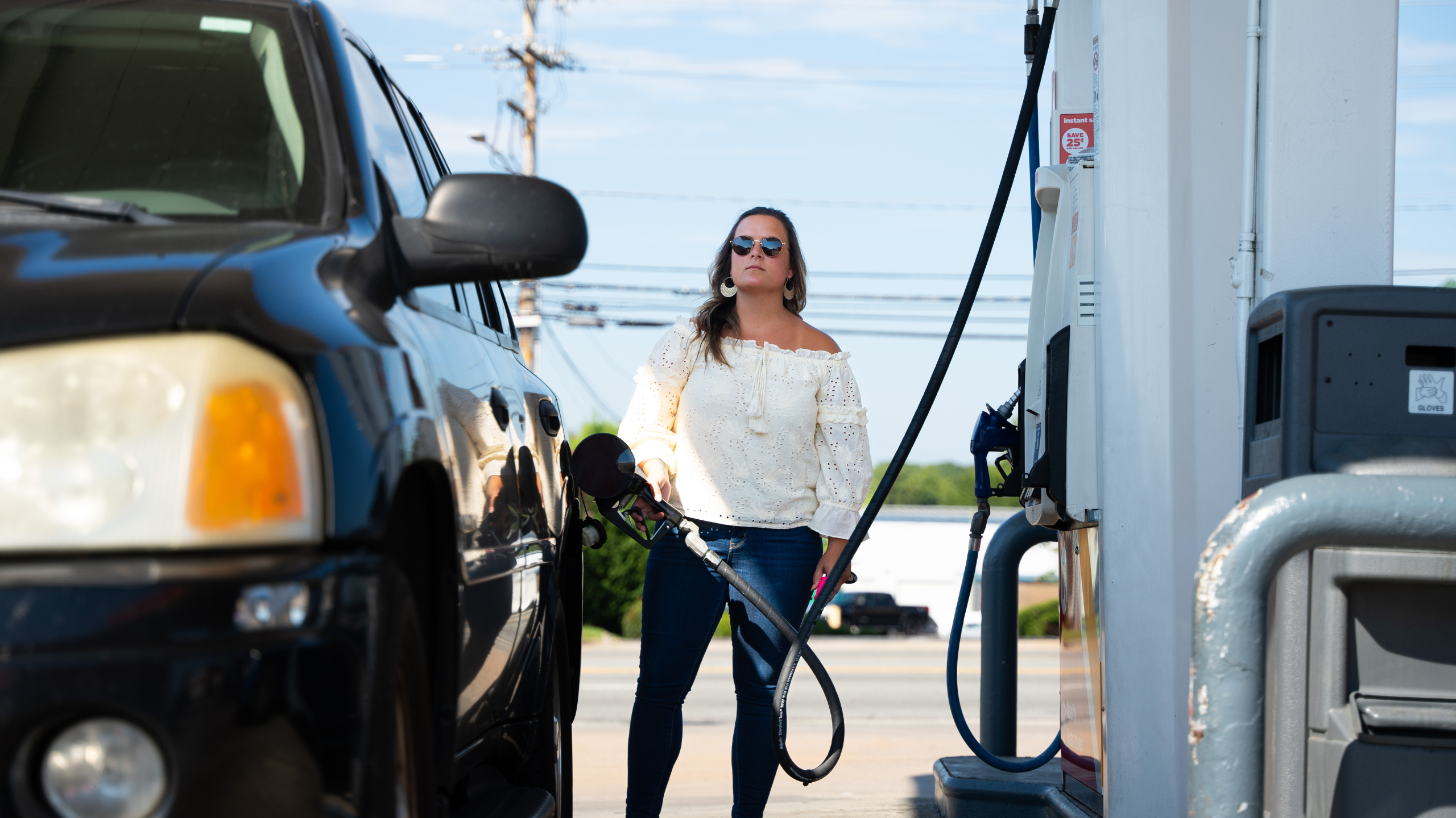 woman alert looking around while pumping gas