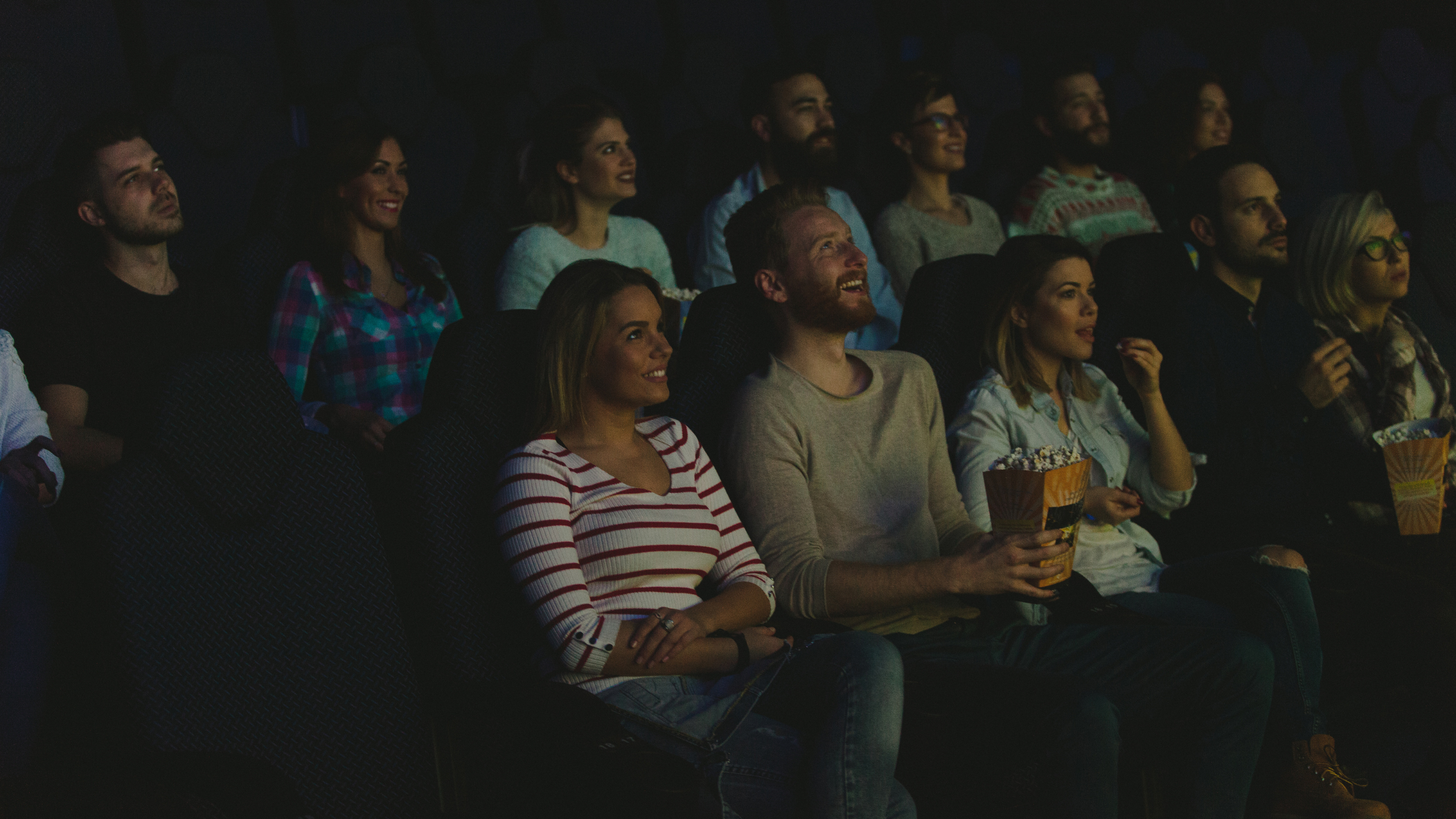 people watching a movie in a dark theatre