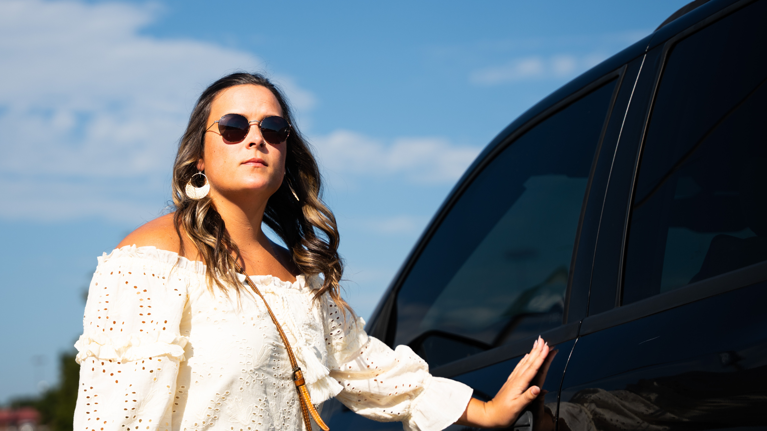 woman closing and locking car door in parking lot